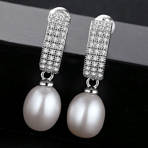 White freshwater pearl dangle earrings with pavé-CZ huggies in sterling silver.