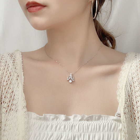 Woman wearing Eiffel-inspired sterling silver necklace with moissanite and CZ accents.