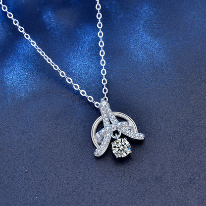 Overhead shot of sterling silver Eiffel pendant necklace with 0.5 ct moissanite center stone.