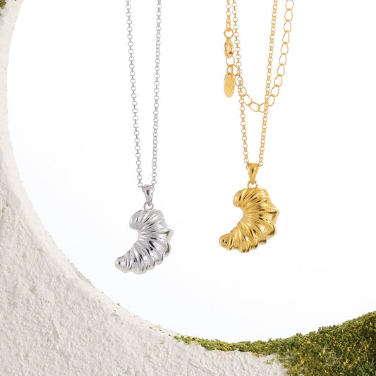 Silver and gold croissant pendant necklaces displayed side by side