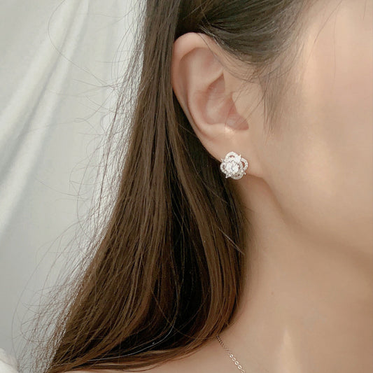 Model wearing quatrefoil moissanite stud earring in 925 sterling silver