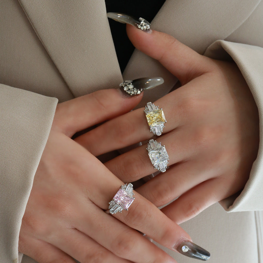 Model stacking radiant-cut CZ cocktail rings with baguette accents in sterling silver; white, yellow and pink.