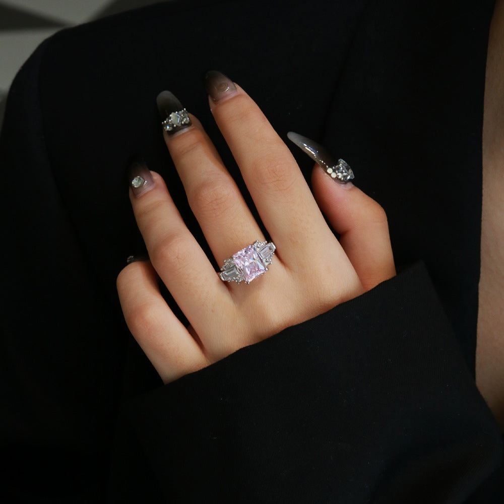 Pink radiant-cut CZ cocktail ring with baguette and round accents in rhodium-plated 925 sterling silver, worn on hand.