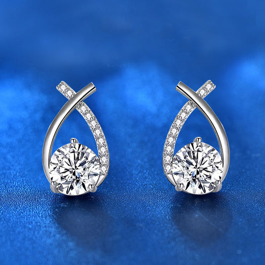 Front view of ribbon-twist moissanite stud earrings in rhodium-plated 925 sterling silver with pavé CZ accents on blue