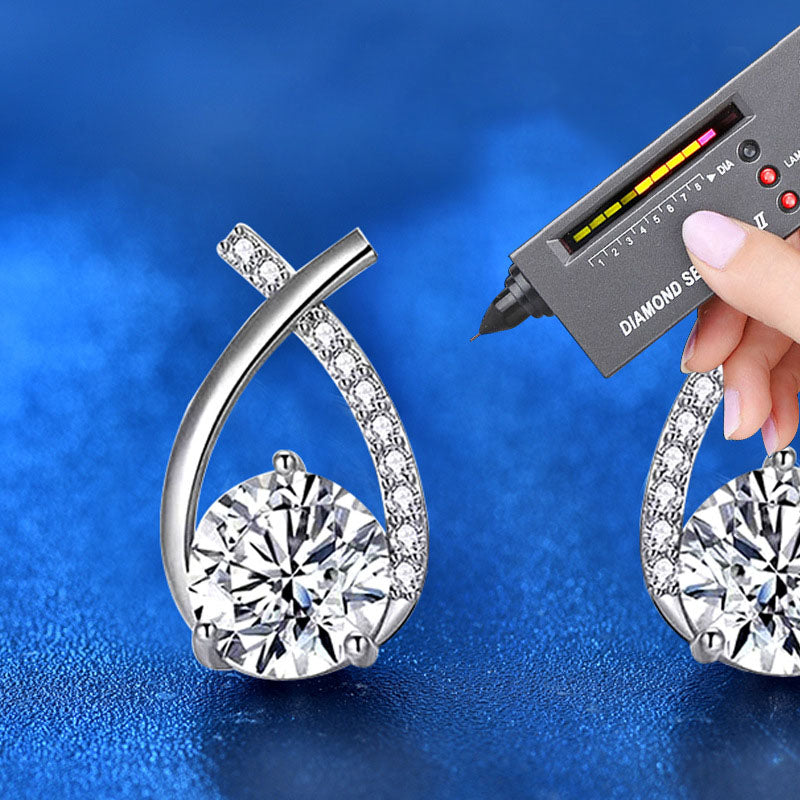 Close-up of ribbon-twist moissanite stud earrings tested with a diamond tester, rhodium-plated sterling silver