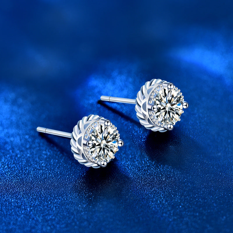 Angled side view showing prong-set round moissanite studs with rope halo in sterling silver