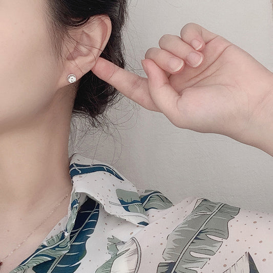 Model wearing a small rope-halo moissanite stud earring in sterling silver