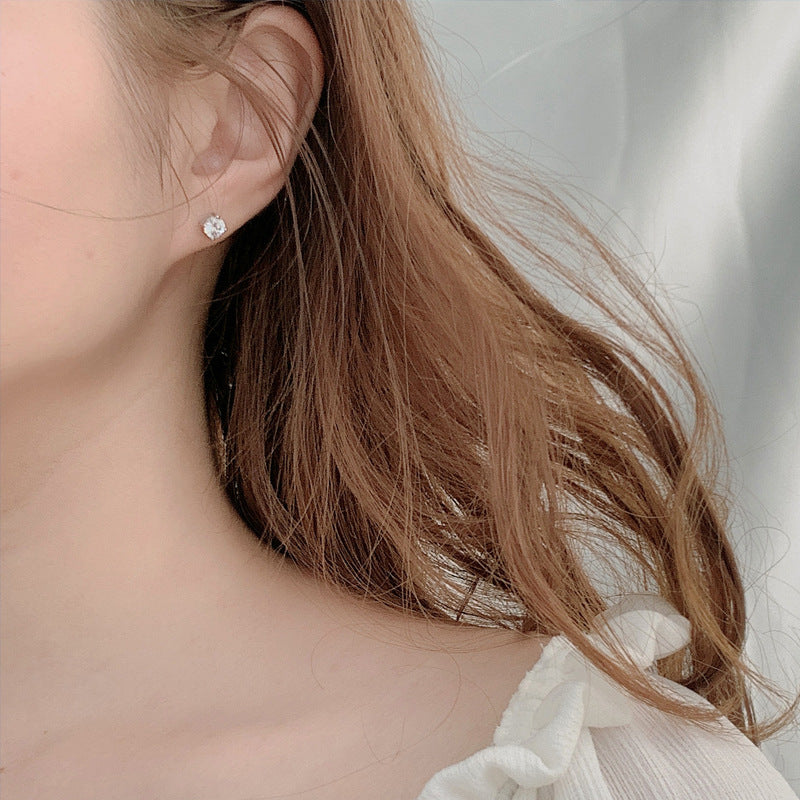 On-ear scale of classic moissanite stud earring in 925 sterling silver on model