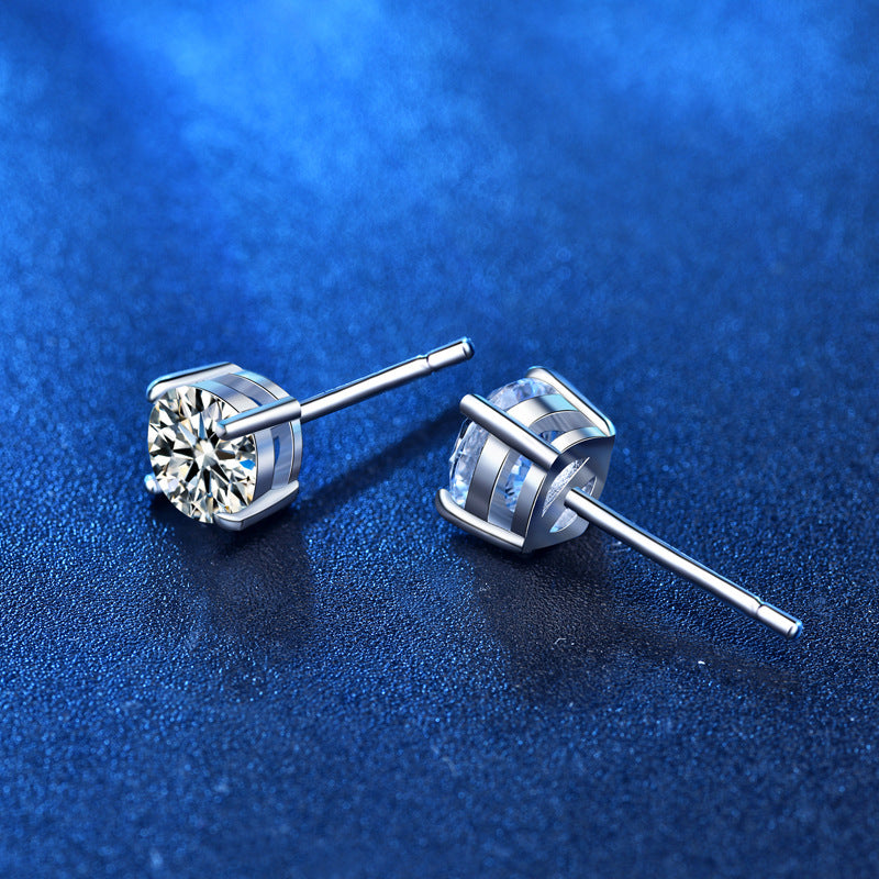 Angled close-up of moissanite stud earrings with four-prong basket in sterling silver