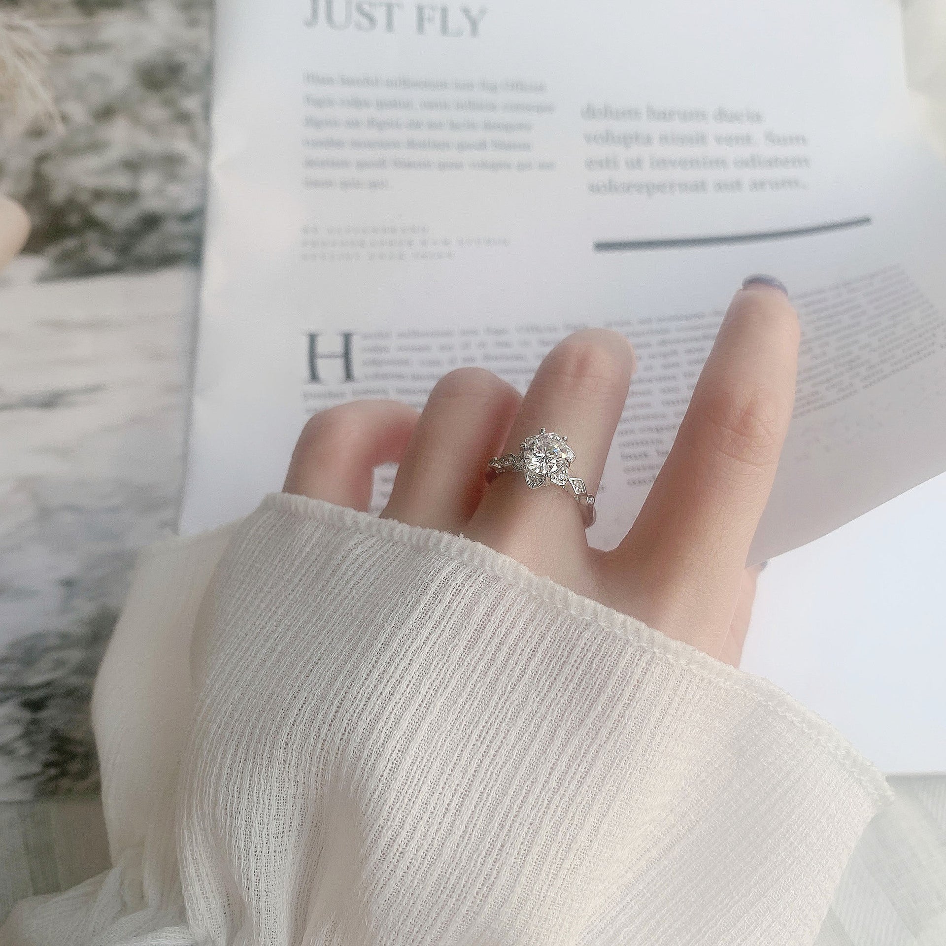 Moissanite starflower ring worn on hand, showcasing delicate floral halo and vintage milgrain in sterling silver
