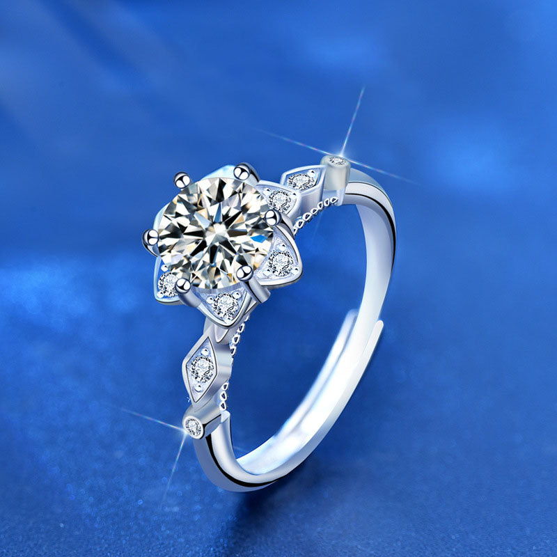 Angled view of starflower moissanite ring in rhodium-plated 925 silver with marquise CZ accents and six-prong center.