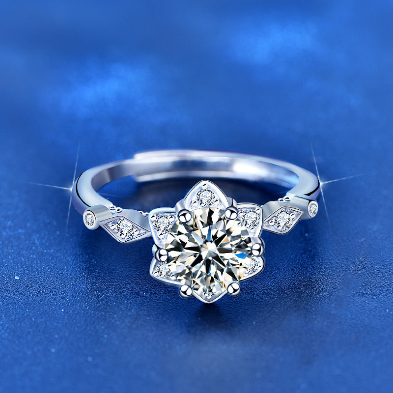 Top view of starflower moissanite engagement ring with floral halo and marquise CZ shoulders in polished sterling silver.