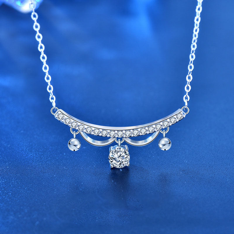 Front view sterling silver lace arc necklace with 0.5 ct lab-grown moissanite drop and CZ tassel accents on blue background.