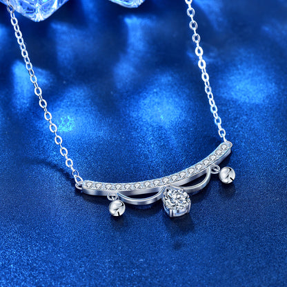 Angled close-up of lace arc moissanite tassel drop necklace in rhodium-plated sterling silver on blue surface.