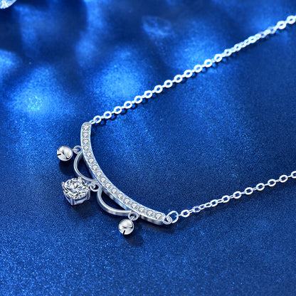 Close-up of CZ pavé arc with moissanite drop and tiny tassels on chain, blue textured background.