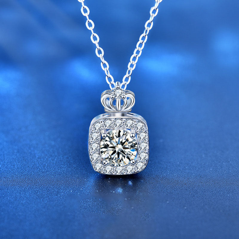 Close-up of sterling silver perfume bottle pendant necklace with sparkling moissanite and CZ crown on blue background