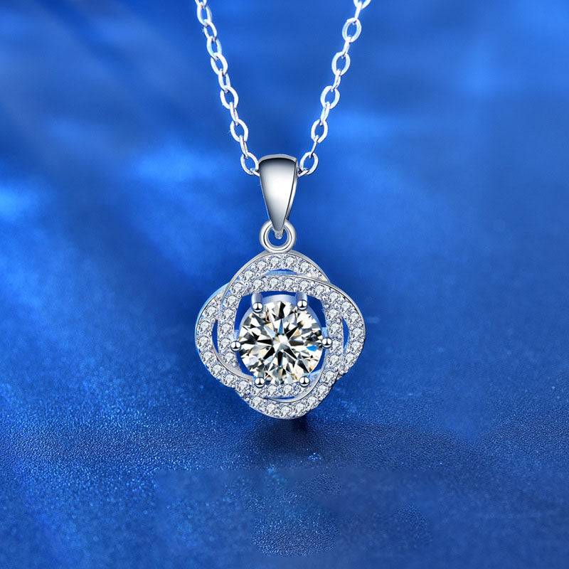 Close-up of 1 carat moissanite rose flower pendant in rhodium-plated 925 sterling silver on blue background