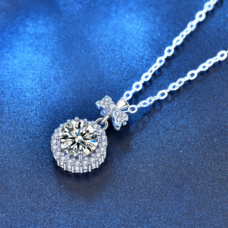 Macro shot of round-cut moissanite pendant with cubic zirconia and bow setting